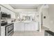 Charming kitchen featuring white cabinets, modern appliances, and an open view of the living space at 5217 Chase Oaks Dr, Sarasota, FL 34241