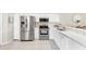 Well-lit kitchen with stainless steel appliances, white cabinets, and tile flooring at 5217 Chase Oaks Dr, Sarasota, FL 34241