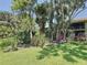 Expansive backyard featuring mature trees and lush greenery with views of the home's patio at 5234 Lake Arrowhead Trl # 30, Sarasota, FL 34231