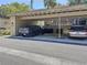 Carport with covered parking and two vehicles parked underneath with nearby storage containers at 5234 Lake Arrowhead Trl # 30, Sarasota, FL 34231
