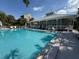 Community pool surrounded by lounge chairs with bright blue water at 5234 Lake Arrowhead Trl # 30, Sarasota, FL 34231
