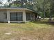 Exterior side of the house, showcasing large windows and outdoor space for relaxation at 6013 Idle A While Cir, Dade City, FL 33523