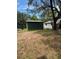 View of the backyard featuring a storage shed and partially covered area, offering additional storage and outdoor space at 6013 Idle A While Cir, Dade City, FL 33523