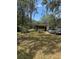 Residential property with a well and lush greenery, and a car parked in the driveway at 6013 Idle A While Cir, Dade City, FL 33523