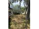 Lawn view featuring a single-story home nestled among mature trees, showcasing its quaint charm and natural surroundings at 6013 Idle A While Cir, Dade City, FL 33523