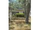 Exterior view of a single-story home featuring mature trees and green shrubs accentuating its serene residential setting at 6013 Idle A While Cir, Dade City, FL 33523