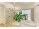 Bathroom showcasing a glass-enclosed shower and soaking tub, accented by tile and natural light at 6102 Sonesta Ct, Bradenton, FL 34202