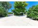 Wide concrete driveway lined with lush landscaping and mature trees providing shade and curb appeal at 6102 Sonesta Ct, Bradenton, FL 34202