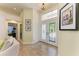 Bright foyer featuring tile flooring, glass front doors with transom window, and elegant lighting at 6102 Sonesta Ct, Bradenton, FL 34202