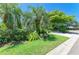 Well-manicured front yard with lush green grass, mature trees, and beautifully landscaped flowerbeds at 6102 Sonesta Ct, Bradenton, FL 34202