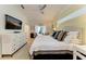 Bright main bedroom with a ceiling fan, TV, and elegant furnishings, leading to a private outdoor area at 6102 Sonesta Ct, Bradenton, FL 34202