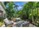 Inviting patio with wicker seating, lush tropical landscaping and a charming gravel path under a sunny blue sky at 6102 Sonesta Ct, Bradenton, FL 34202