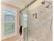 This shower features gray tile and a window with wood shutters at 6102 Sonesta Ct, Bradenton, FL 34202