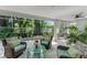 Serene sunroom features wicker furniture and access to pool with tropical landscaping at 6102 Sonesta Ct, Bradenton, FL 34202