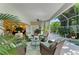 Relaxing sunroom with comfortable wicker seating and serene views of the lush greenery outdoors at 6102 Sonesta Ct, Bradenton, FL 34202