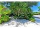 Beautifully landscaped yard featuring mature trees, lush greenery, and a wrought iron bench at 6102 Sonesta Ct, Bradenton, FL 34202