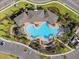 Birds-eye view of pool with lounge seating, palm trees, clubhouse and parking area at 6314 Distant Haze Pl, Palmetto, FL 34221