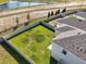 An aerial view of a fenced backyard with green grass near a pond and trees, providing a serene outdoor space at 6314 Distant Haze Pl, Palmetto, FL 34221