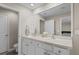 Bathroom featuring double sinks with white cabinets and a bright modern mirror at 6314 Distant Haze Pl, Palmetto, FL 34221