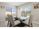 Bright dining area with glass-top table, stylish chairs, and backyard views at 6314 Distant Haze Pl, Palmetto, FL 34221