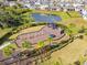 Aerial view of a vibrant community playground complete with swings, climbing structures, and surrounded by lush palm trees at 6314 Distant Haze Pl, Palmetto, FL 34221