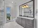 Coastal-style bathroom with gray vanity, shower, and views of the ocean at 641 Ranger Ln, Longboat Key, FL 34228