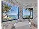 Bright bathroom with a modern tub, gorgeous ocean view, and elegant marble finishes at 641 Ranger Ln, Longboat Key, FL 34228