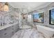 Elegant bathroom featuring unique marble tiling, modern fixtures, a soaking tub, and a frameless glass shower at 641 Ranger Ln, Longboat Key, FL 34228