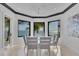 Dining area with water view windows, a modern ceiling fan, and seating for six guests at 641 Ranger Ln, Longboat Key, FL 34228