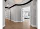 Bright hallway featuring hardwood floors, decorative lighting, and an open doorway to a bedroom with a four-poster bed at 641 Ranger Ln, Longboat Key, FL 34228