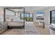 Beautiful main bedroom with four-poster bed, fireplace, television, and stunning water views from expansive windows at 641 Ranger Ln, Longboat Key, FL 34228