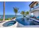 Inviting waterfront pool and spa surrounded by palm trees and lounge chairs under a clear blue sky at 641 Ranger Ln, Longboat Key, FL 34228