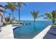 Beautiful in-ground pool and spa overlooking the ocean, surrounded by lush greenery and palm trees at 641 Ranger Ln, Longboat Key, FL 34228