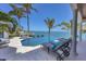A stunning outdoor pool area with in-ground spa, lounge chairs, palm trees and beautiful ocean views at 641 Ranger Ln, Longboat Key, FL 34228