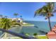 A clear view of the ocean from a balcony, highlighting lush greenery, a neighboring property, and docks at 641 Ranger Ln, Longboat Key, FL 34228
