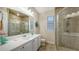 Well-lit bathroom featuring tiled shower with glass door and large vanity at 6919 Dominion Ln, Lakewood Ranch, FL 34202