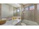 Tiled bathroom featuring a shower/tub, a marble countertop, and a large mirror at 6919 Dominion Ln, Lakewood Ranch, FL 34202