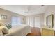 Cozy bedroom with wood floors, ceiling fan, white walls, and comfortable furnishings at 6919 Dominion Ln, Lakewood Ranch, FL 34202
