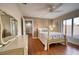 Bedroom with ceiling fan, neutral colors, four-poster bed, wood floors, dresser, and window with blinds at 6919 Dominion Ln, Lakewood Ranch, FL 34202