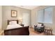 Comfortable bedroom with a wood bed frame, a leather chair, wood flooring, and a window at 6919 Dominion Ln, Lakewood Ranch, FL 34202
