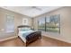 Cozy bedroom with wood floors, a large window with blinds, and a classic wooden bed frame at 6919 Dominion Ln, Lakewood Ranch, FL 34202