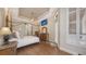 Bedroom showcasing a four poster bed, wood floors, recessed ceiling, and outdoor access at 6919 Dominion Ln, Lakewood Ranch, FL 34202