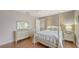 Comfortable bedroom with wood floors, a four-poster bed, and stylish furnishings at 6919 Dominion Ln, Lakewood Ranch, FL 34202