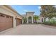 Stately home with a lush, landscaped front yard, mature tree and circular driveway at 6919 Dominion Ln, Lakewood Ranch, FL 34202