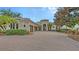 Stately home with a lush, landscaped front yard, mature tree and circular driveway at 6919 Dominion Ln, Lakewood Ranch, FL 34202