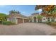 Stately home with a lush, landscaped front yard, mature tree and circular driveway at 6919 Dominion Ln, Lakewood Ranch, FL 34202