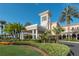 Beautiful building with lush landscaping, a circular driveway, and tall palm trees creating a welcoming entrance at 6919 Dominion Ln, Lakewood Ranch, FL 34202