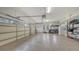 Spacious garage with epoxy flooring, storage shelves, bright lighting, and windows on the garage doors at 6919 Dominion Ln, Lakewood Ranch, FL 34202