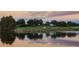 Scenic golf course landscape at sunset, featuring a tranquil lake reflecting the sky and manicured green fairways at 6919 Dominion Ln, Lakewood Ranch, FL 34202