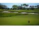 Beautiful golf course featuring manicured greens, sand traps, and mature trees against a blue sky at 6919 Dominion Ln, Lakewood Ranch, FL 34202